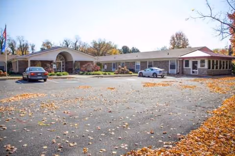 Exterior view of Signature HealthCARE of East Louisville building with a parking lot and autumn leaves.