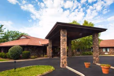 Exterior view of Florence Park Care Center with brick canopy entrance and surrounding greenery.
