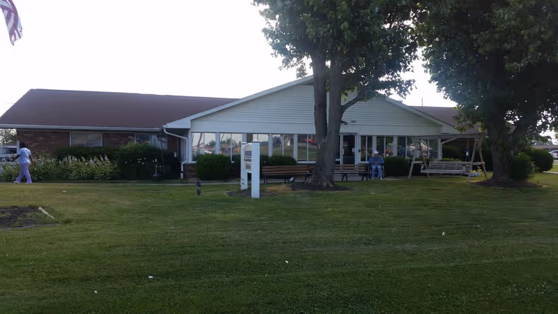 Hardinsburg Nursing and Rehabilitation exterior with glass-front entrance and benches.