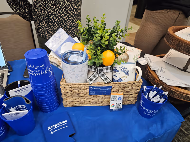 Promotional display at Morgantown Care & Rehabilitation Center table with branded items.