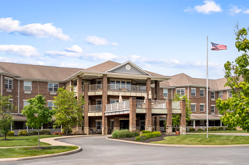 Exterior of Magnolia Springs Florence senior living facility with brick entrance and flagpole.