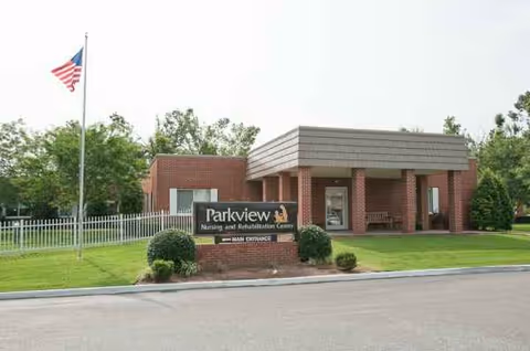 Front view of Parkview Nursing and Rehabilitation Center with sign and flagpole