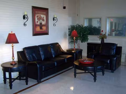 Black leather sofa set with coffee table in a bright living room lounge.