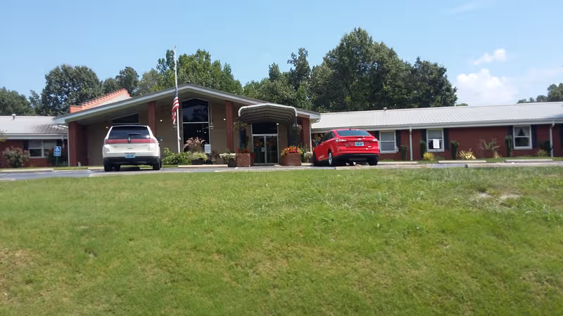 Front view of Christian Care Center of Kuttawa, a brick, single-story facility with cars parked.