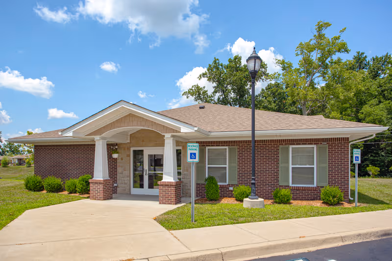 Forest Springs Health Campus exterior: a single-story brick facility with a covered entrance.