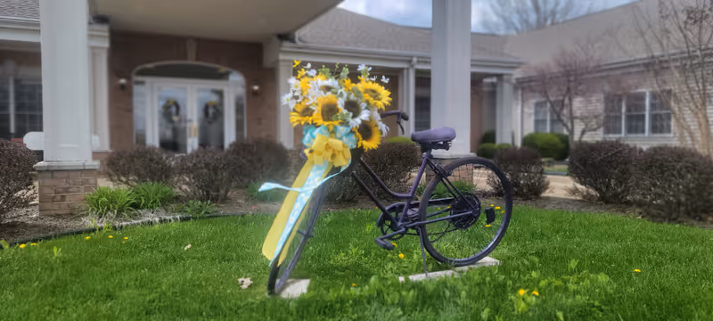 Front exterior of Paragon of Madisonville featuring a flower-decorated bicycle on the lawn.