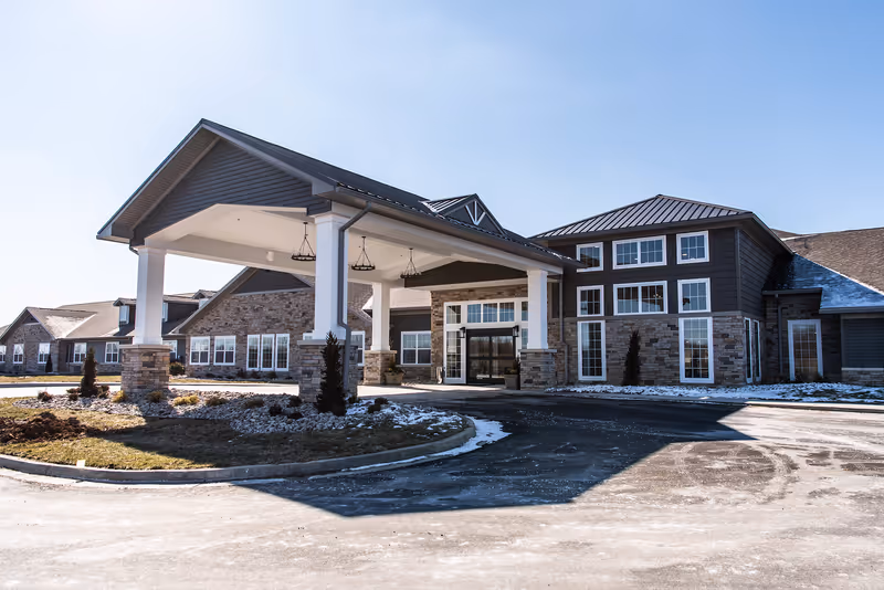 Exterior view of Charter Senior Living Murray entrance with porte-cochère and stone facade.