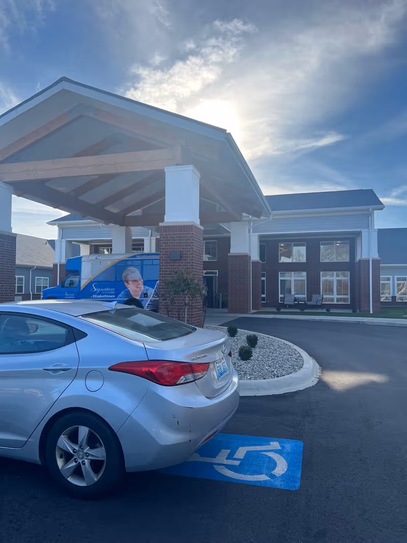 Exterior view of Signature HealthCARE of Elizabethtown entrance with a parked car