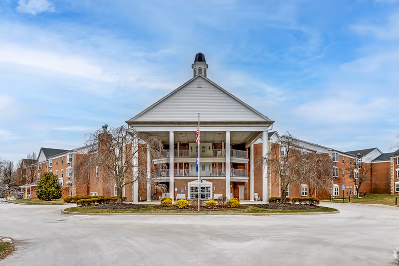 Front view of Colonial Heights Senior Living building with columns and a circular driveway
