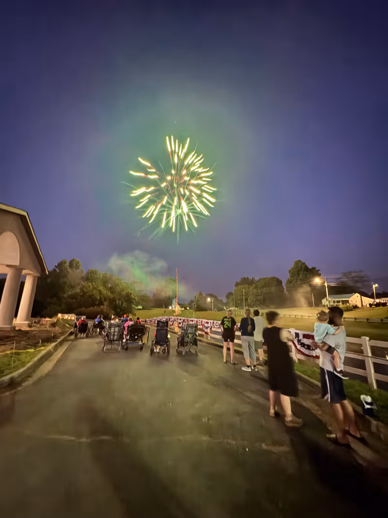 Night outdoor scene at Countryside Center with a fireworks display above a group of residents