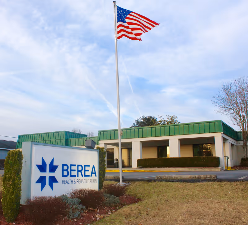 American flag flies over the Berea Health and Rehabilitation front building and sign.