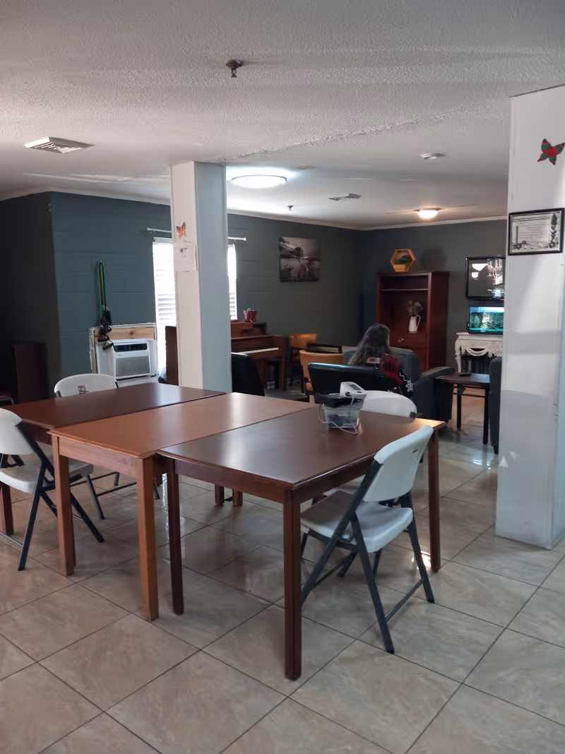 Communal dining area in a senior living facility with tables and chairs.