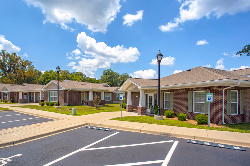 Exterior view of Forest Springs Health Campus: brick single-story buildings, parking lot, and manicured lawns.