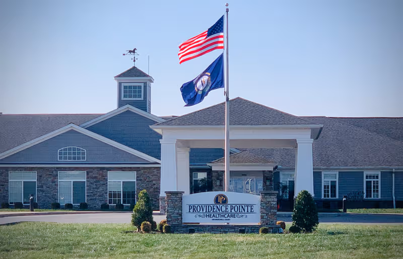 Front view of Providence Pointe Healthcare building with flagpoles and entrance signage.