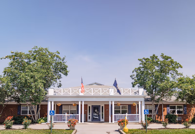Front view of Liberty Care and Rehabilitation Center showing entrance and flags.