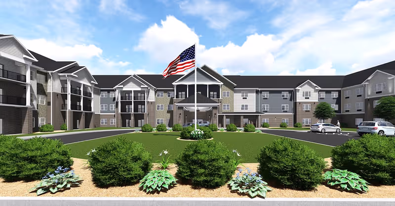 Front exterior view of a senior living community with flagpole and landscaped entry.