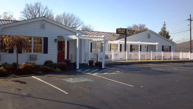 A single-story white nursing home with a long porch and Golden Years sign.