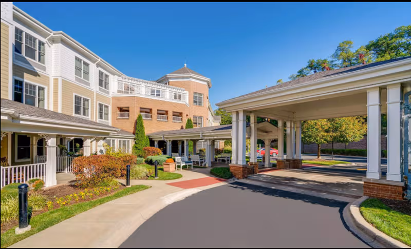 Sunrise of Louisville exterior: multi-story senior living facility with covered entrance, driveway, and landscaped grounds.