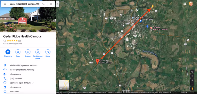 Exterior view of Cedar Ridge Health Campus with a red sign, greenery, and a map route.