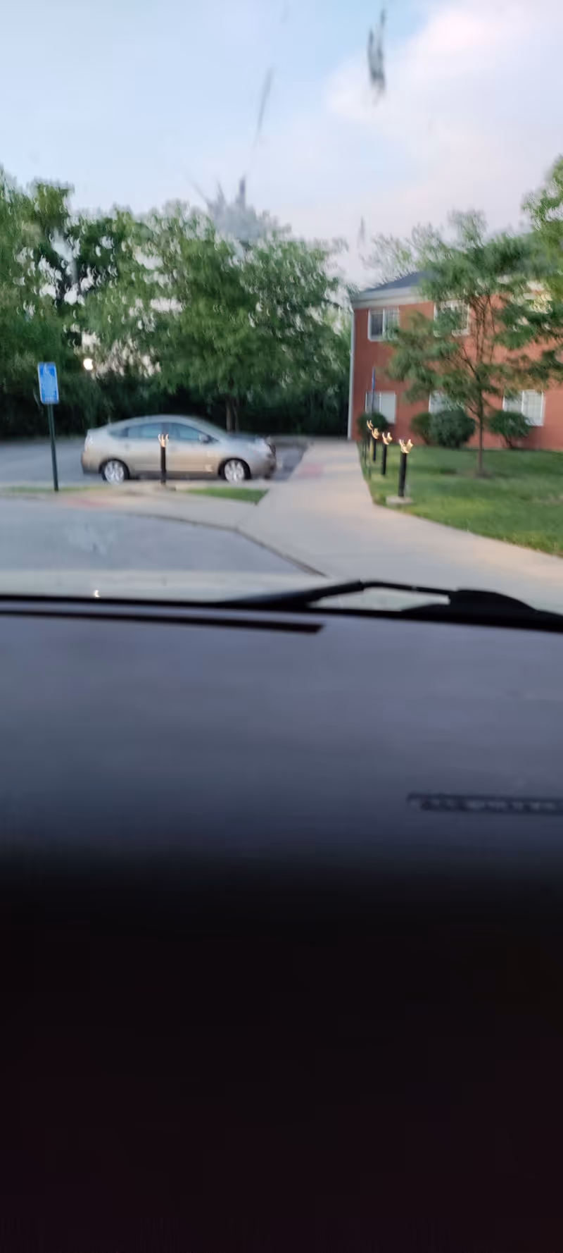 View from inside a car of building exterior and parking lot at Colonial Heights Senior Living.