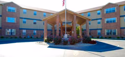 Exterior view of Brookdale Murray senior living building with covered entrance and flagpole.