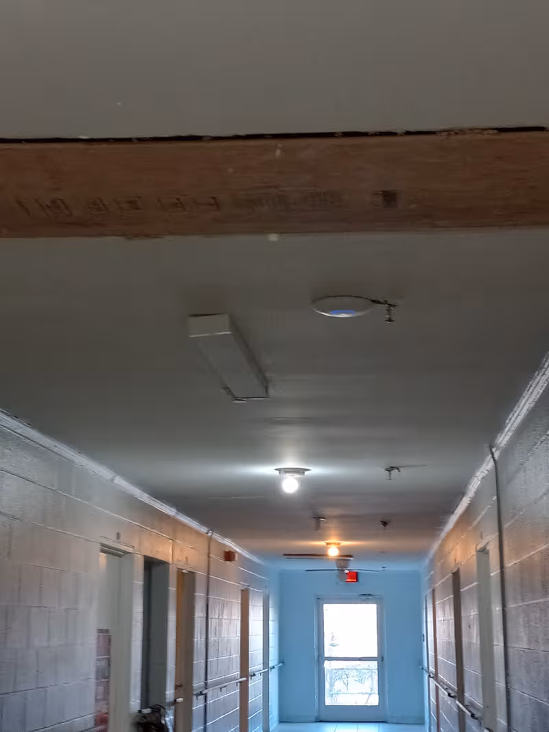 Long indoor hallway in a senior living facility with doors along both sides