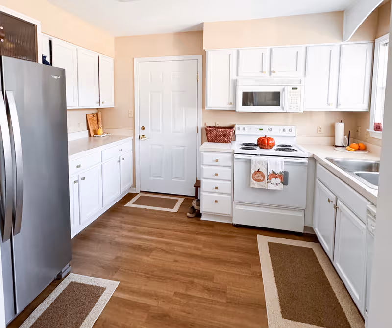 Bright white kitchen featuring stainless appliances and ample cabinetry.