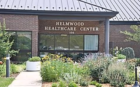 Exterior view of Helmwood Healthcare Center with brick facade and landscaped garden.