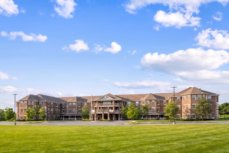 Exterior view of Magnolia Springs Florence senior living facility with lawn and blue sky