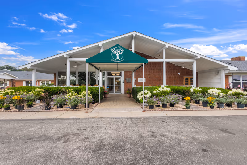 Front view of Grayson Nursing and Rehabilitation Center with a covered entrance and flowering plants