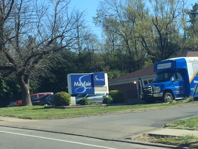 Exterior view of Mayfair Manor with a blue van parked near the building.