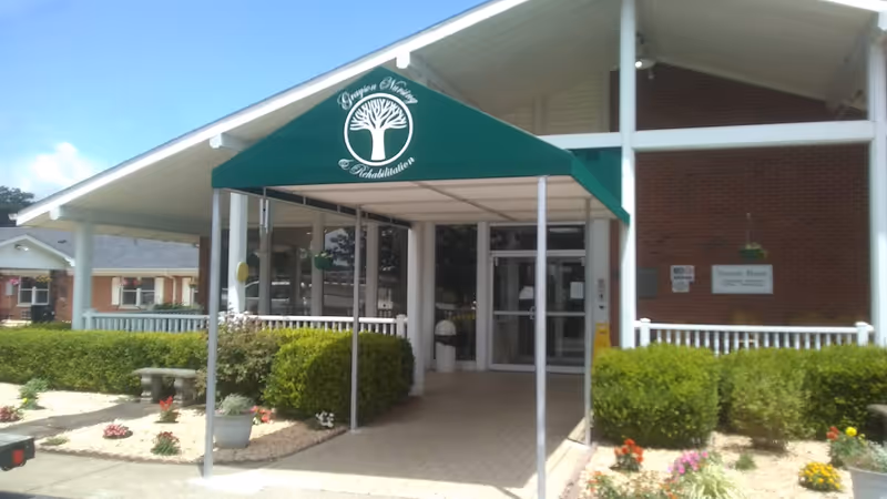 Front entrance of Grayson Nursing and Rehabilitation Center with green canopy and landscaping.