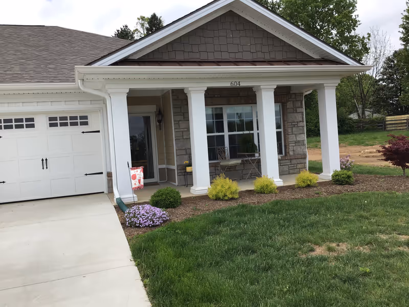 Front view of Daisy Hill Senior Living building with porch, columns, and landscaped yard.