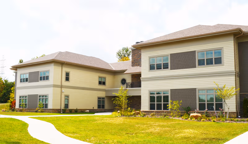 Exterior view of Emerald Trace on Turkeyfoot senior living facility with manicured lawn.