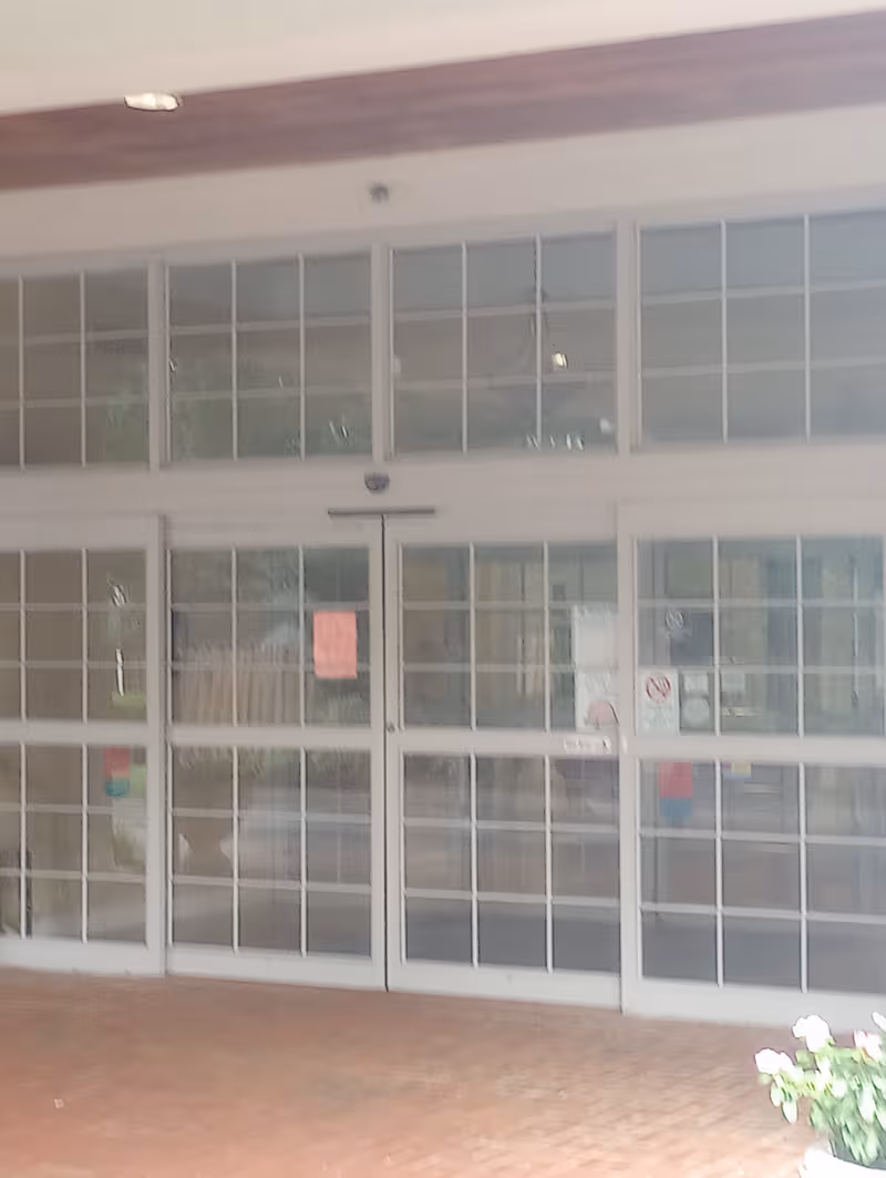 Front entrance of Signature HealthCARE at Jefferson Place with glass doors and large windows.