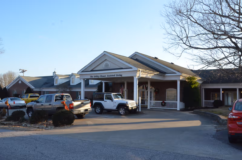 The Stilley House Assisted Living front entrance with cars in the parking lot