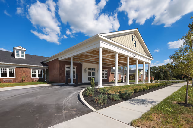 Hallmark House senior living facility entrance with white columns and a covered porch.