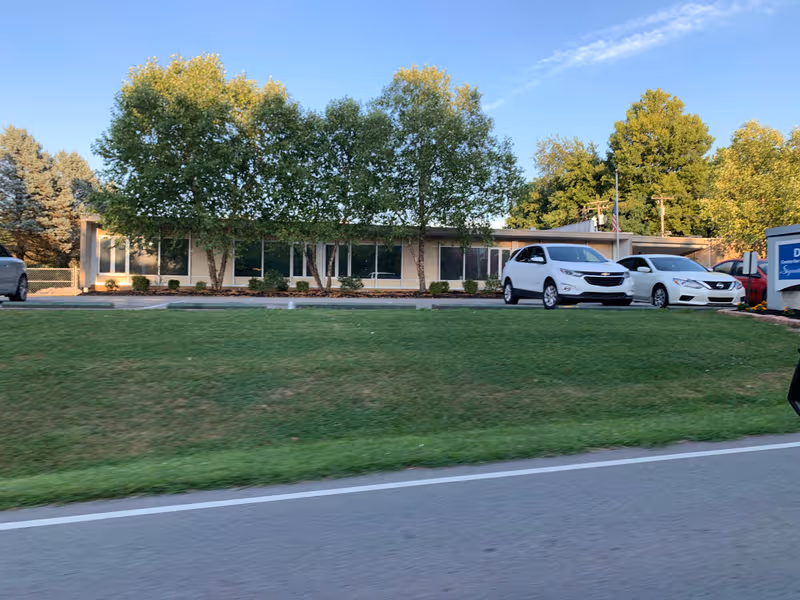 Exterior view of Danville Centre for Health and Rehabilitation with trees and parked cars.