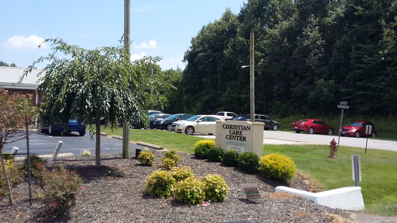 Exterior view of Christian Care Center sign, parking lot, and manicured landscaping.