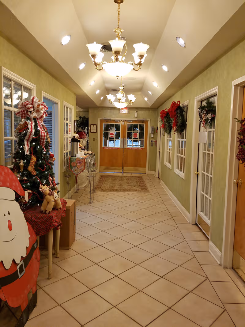 Festive hallway inside Knott County Nursing Home with Christmas decorations and glass doors.