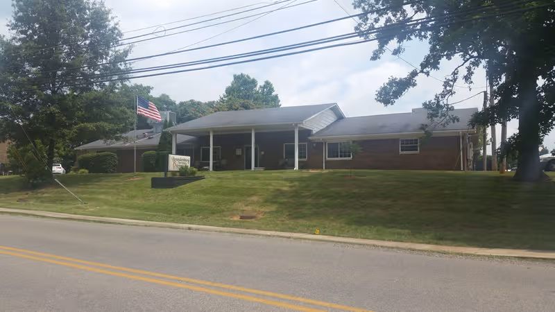 Exterior of Brandenburg Nursing & Rehabilitation Center, a single-story brick building with flag and lawn.