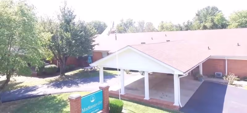 Exterior view of Madisonville Health and Rehabilitation front entrance with a covered drop-off area.
