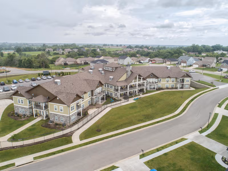 Aerial view of Dominion Senior Living of Richmond campus with tan buildings and green lawns.