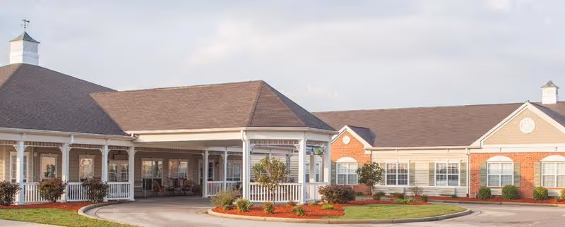 Front entrance and covered porte-cochère of Morning Pointe of Owensboro with a landscaped circular drive.
