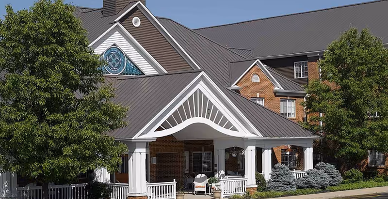 Front view of Celebration Villa of Summit Hills, a brick building with a covered entrance.