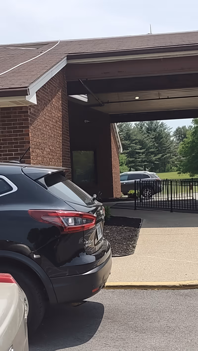 Exterior view of Signature Healthcare at North Hardin entrance with parked cars.