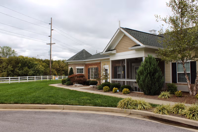 Front exterior of a single-story senior living facility with landscaped yard and walkway