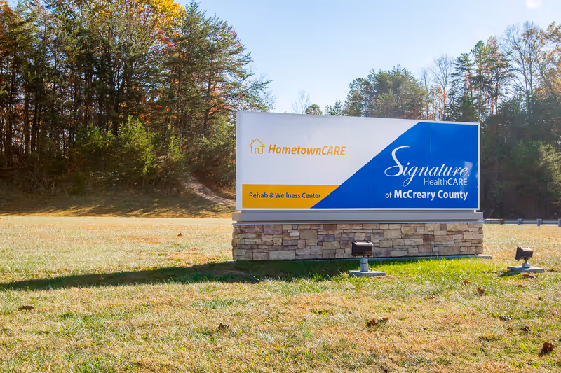 Outdoor sign for Signature HealthCARE of McCreary County on a grassy field.
