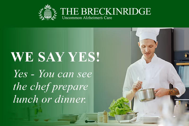 A chef in a white uniform and hat is preparing food in a kitchen. There are fresh vegetables and kitchen utensils on the counter. The image includes text promoting The Breckinridge Memory Care facility, stating 'WE SAY YES! Yes - You can see the chef prepare lunch or dinner.'