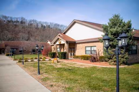 Exterior view of a single-story brick senior living facility with landscaped front yard.